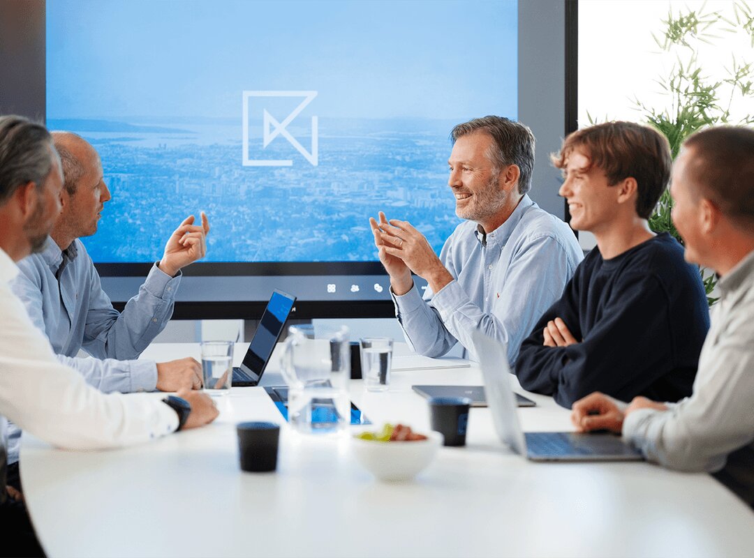 Krysse-møte rundt bordet med Krysse-logoen på skjermen